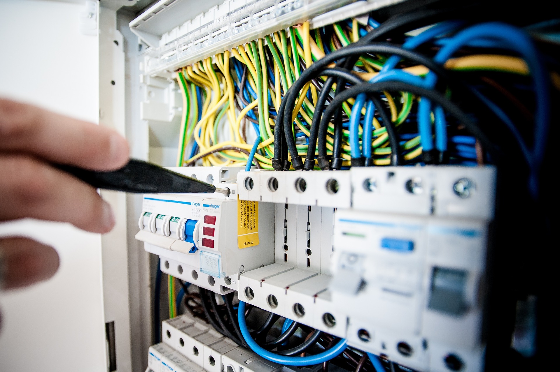 A hand working on a rack of Voice and Data Cabling